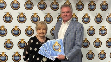 Woman standing next to a man holding an award