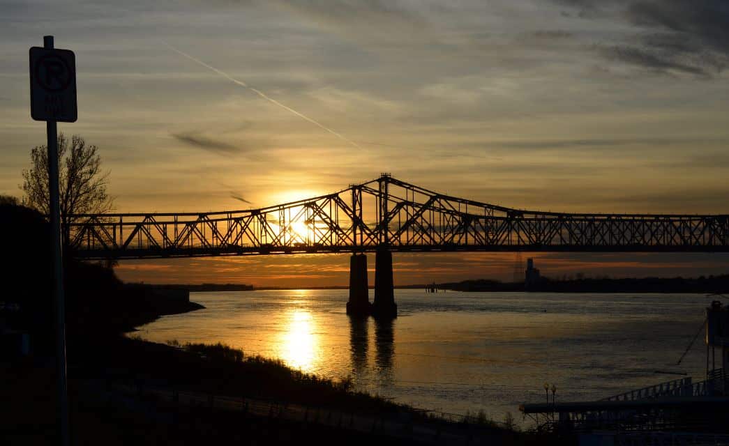 Large bridge over water with setting sun in the background